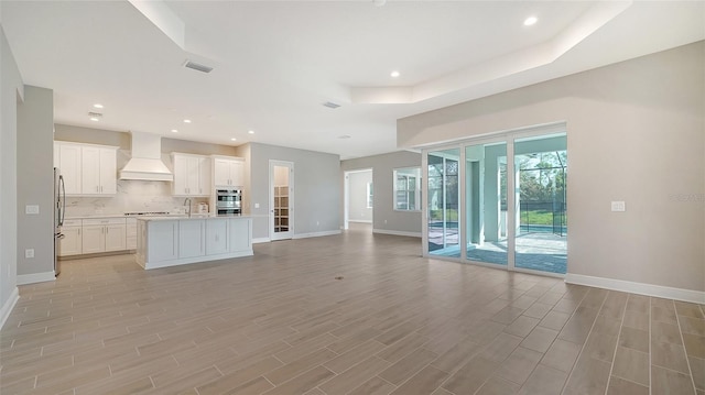 unfurnished living room with light hardwood / wood-style flooring and sink