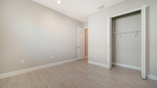 unfurnished bedroom with a closet and light hardwood / wood-style floors