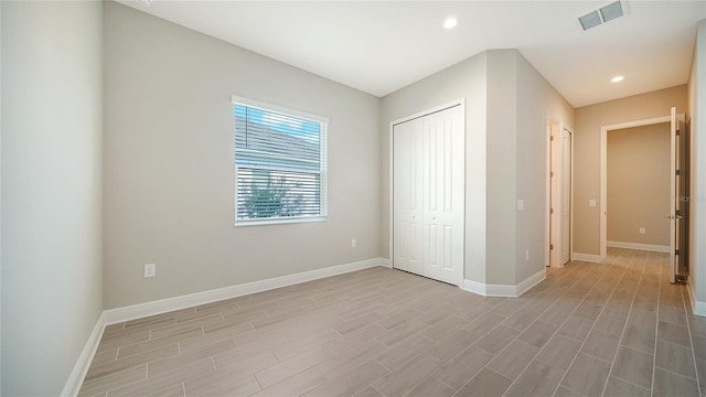 unfurnished bedroom with light hardwood / wood-style flooring and a closet