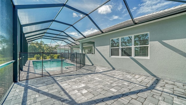 view of swimming pool featuring glass enclosure and a patio