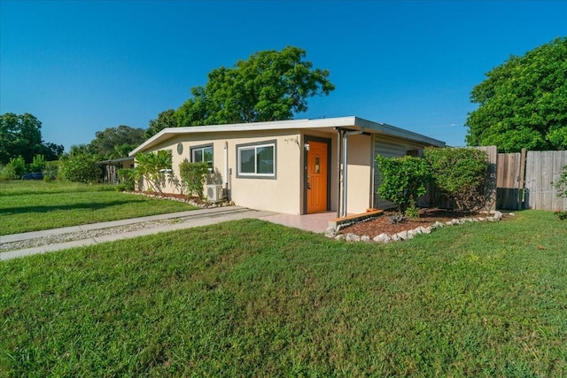 ranch-style home featuring a front yard and cooling unit