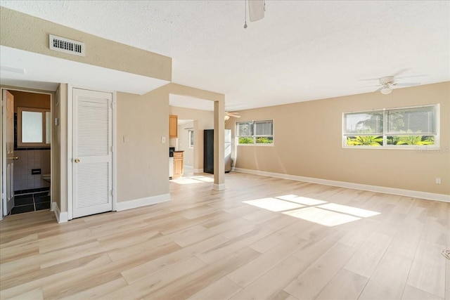 interior space featuring ceiling fan, a textured ceiling, and light hardwood / wood-style flooring