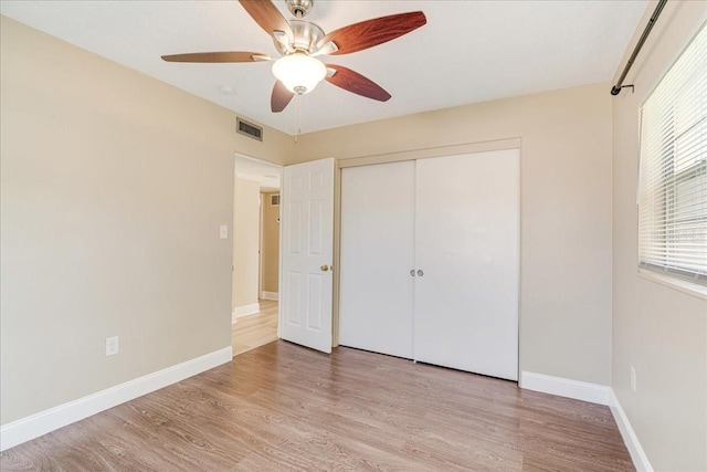 unfurnished bedroom with light hardwood / wood-style floors, ceiling fan, and a closet