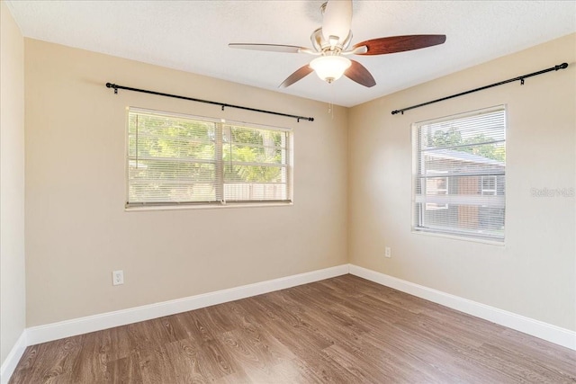 empty room with ceiling fan and hardwood / wood-style flooring