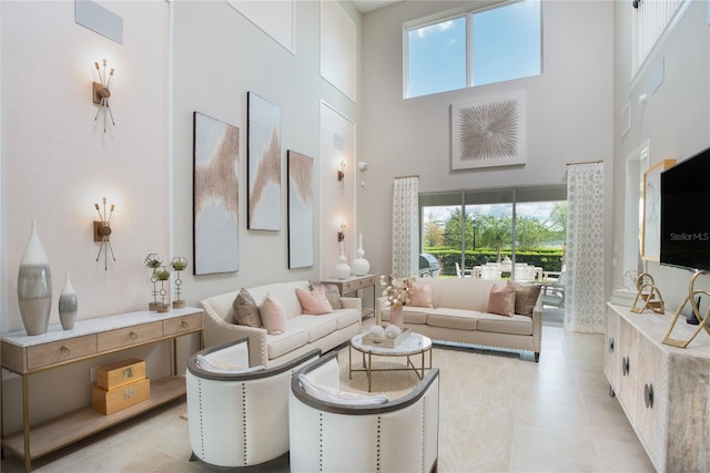 living room featuring a high ceiling, light tile patterned floors, and a healthy amount of sunlight