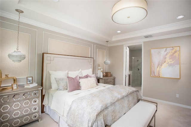 carpeted bedroom with ensuite bath, a tray ceiling, and crown molding