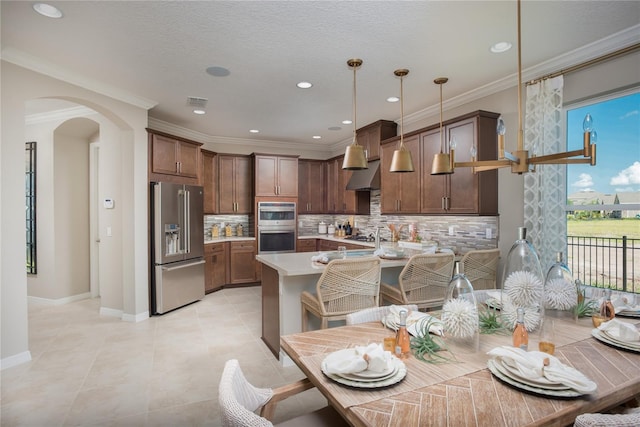 tiled dining space with a textured ceiling and crown molding