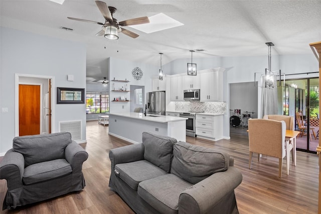 living room with hardwood / wood-style flooring, ceiling fan, and a wealth of natural light