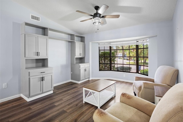 living room with a textured ceiling, lofted ceiling, dark hardwood / wood-style floors, and ceiling fan