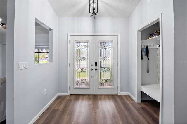 entrance foyer with a textured ceiling, dark hardwood / wood-style flooring, and french doors