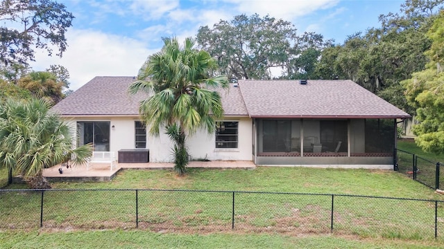 rear view of house with a sunroom and a yard