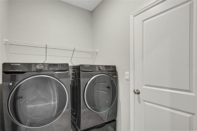 laundry room featuring tile patterned flooring and washing machine and clothes dryer