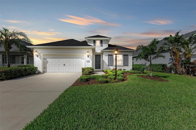 view of front of house with a garage and a yard