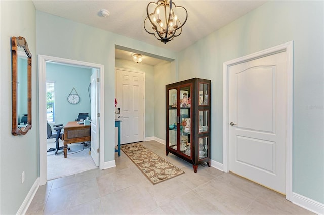 tiled entrance foyer with a notable chandelier