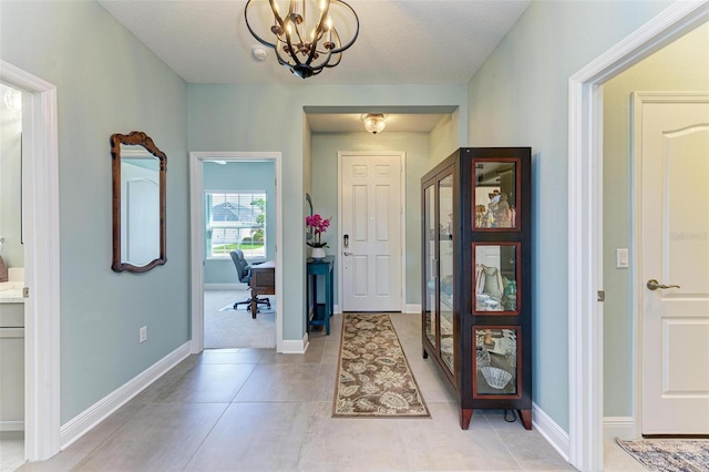 tiled entryway featuring a chandelier