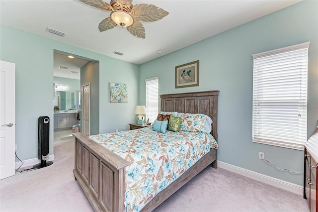 carpeted bedroom with multiple windows, ensuite bath, and ceiling fan