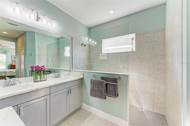 bathroom featuring ceiling fan, tile patterned flooring, vanity, and tiled shower