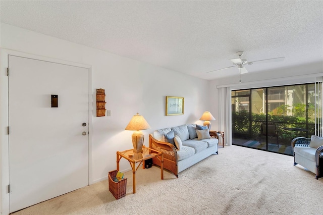 living room with ceiling fan, a textured ceiling, and carpet floors