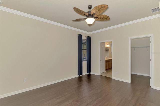 unfurnished bedroom with crown molding, ensuite bath, ceiling fan, a walk in closet, and a closet