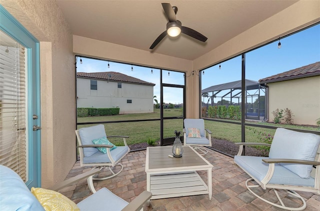 sunroom / solarium featuring ceiling fan and plenty of natural light