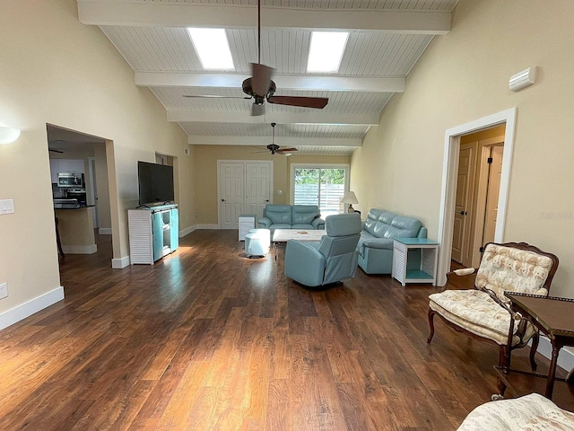 living room featuring beamed ceiling, high vaulted ceiling, a skylight, dark hardwood / wood-style flooring, and ceiling fan