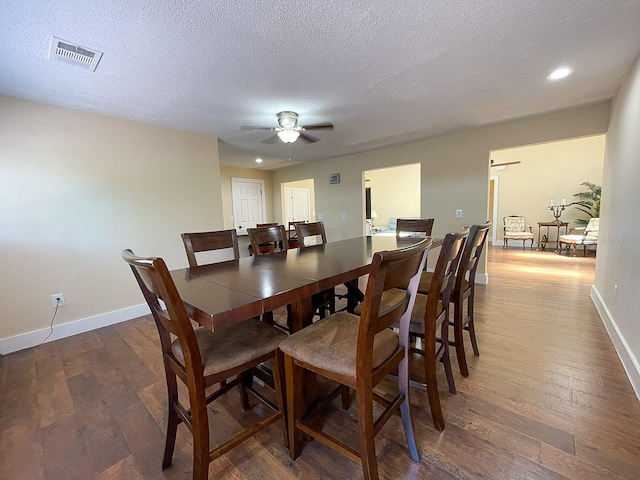 dining area featuring ceiling fan, dark wood-type flooring, and a textured ceiling