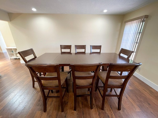 dining space featuring a textured ceiling and dark wood-type flooring