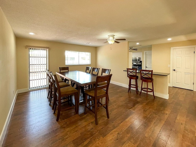 dining space featuring ceiling fan, a textured ceiling, and dark hardwood / wood-style floors