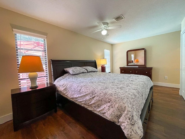 bedroom featuring a textured ceiling, ceiling fan, and dark wood-type flooring