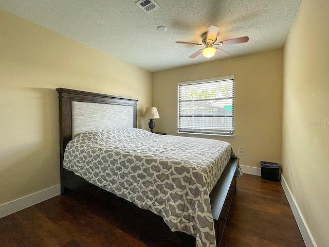 bedroom featuring ceiling fan, a textured ceiling, and dark hardwood / wood-style flooring