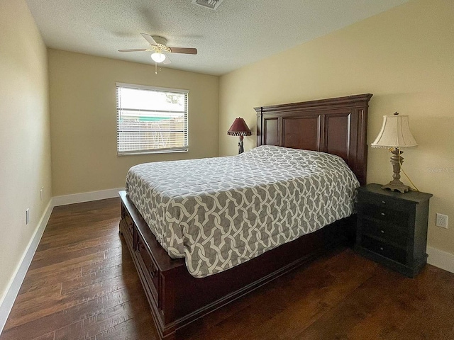 bedroom featuring ceiling fan, a textured ceiling, and dark hardwood / wood-style flooring