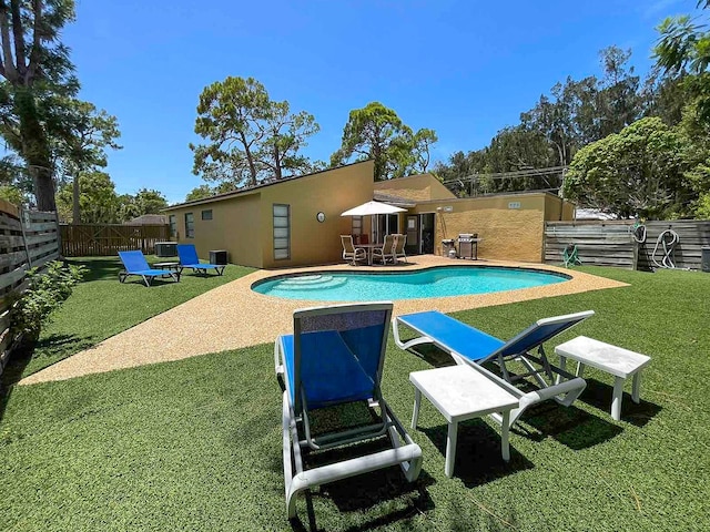 view of pool with a lawn and a patio area