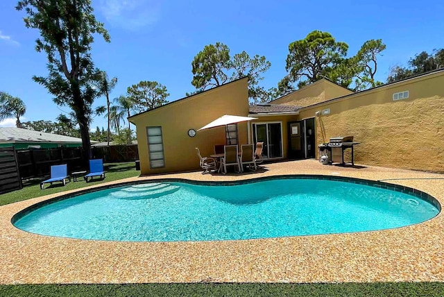 view of swimming pool with a grill and a patio area