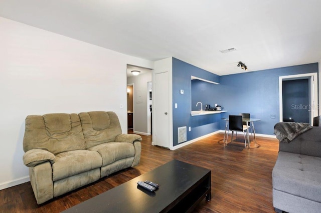 living room featuring sink and dark wood-type flooring