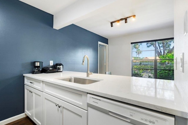 kitchen with light stone counters, white cabinets, white dishwasher, sink, and dark hardwood / wood-style floors