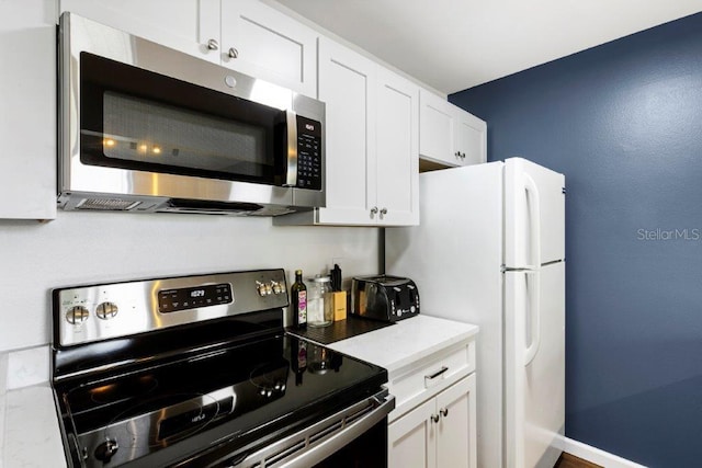 kitchen featuring white cabinets, light stone counters, and appliances with stainless steel finishes