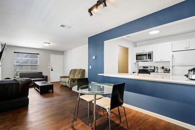 dining area featuring dark wood-type flooring