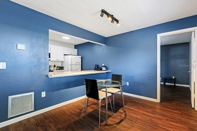 dining room with sink and dark hardwood / wood-style flooring