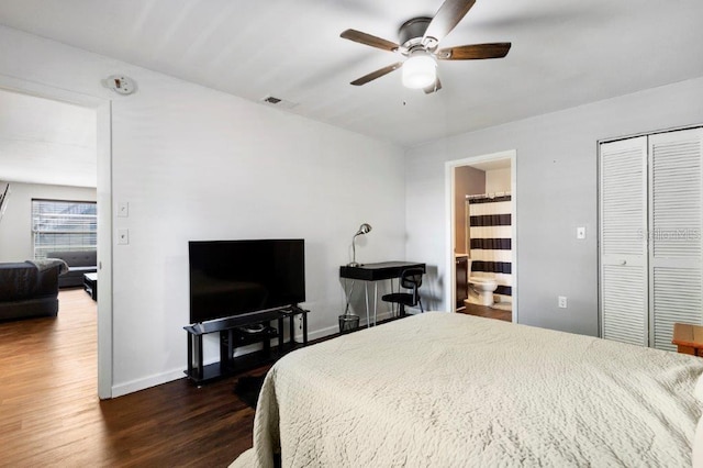 bedroom featuring dark hardwood / wood-style flooring, ceiling fan, ensuite bathroom, and a closet