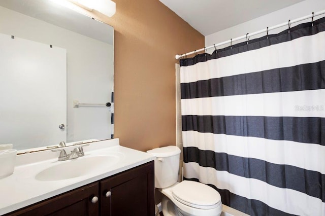 bathroom featuring curtained shower, vanity, and toilet