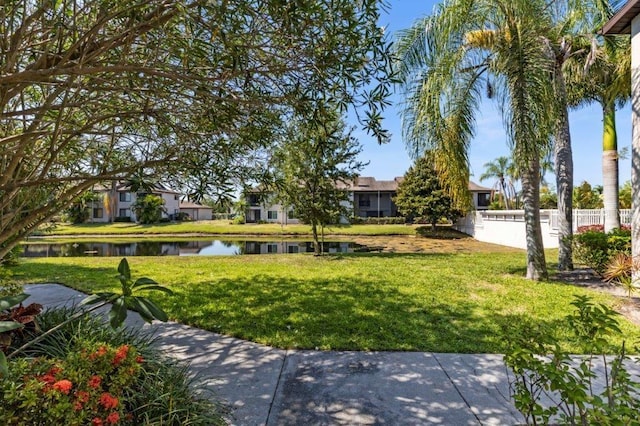 view of property's community with a water view and a yard