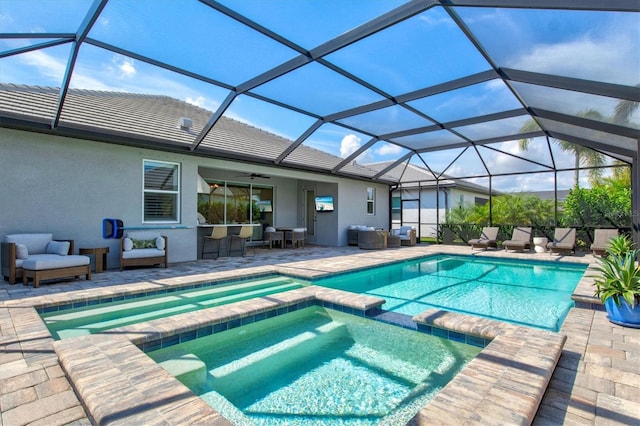 view of pool featuring an in ground hot tub, a bar, glass enclosure, and a patio area