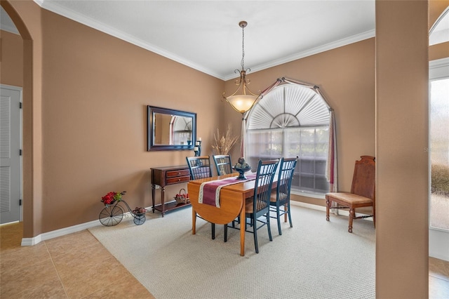 tiled dining room featuring ornamental molding