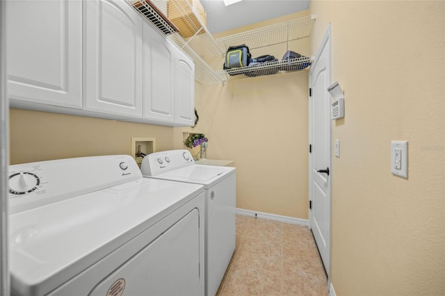 clothes washing area featuring cabinets, light tile patterned floors, and washing machine and dryer