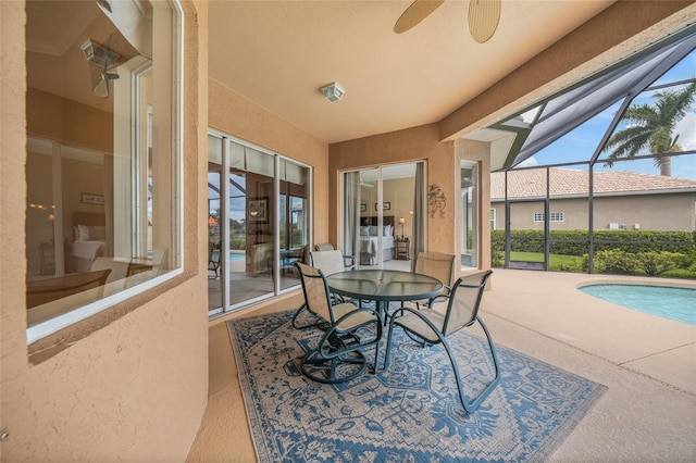 sunroom / solarium with ceiling fan and a swimming pool