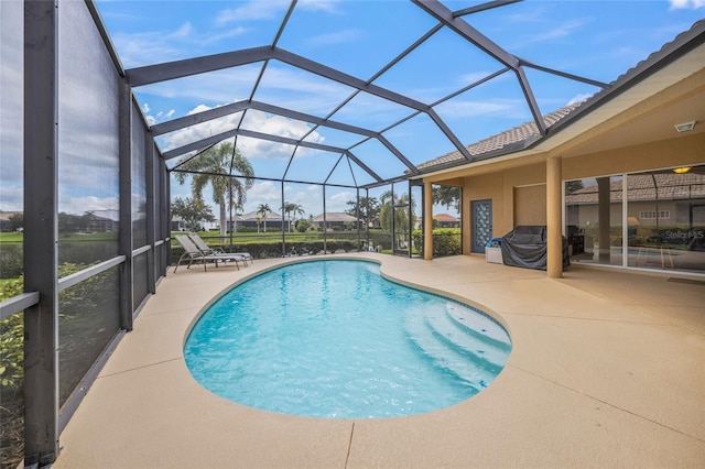 view of swimming pool featuring glass enclosure and a patio