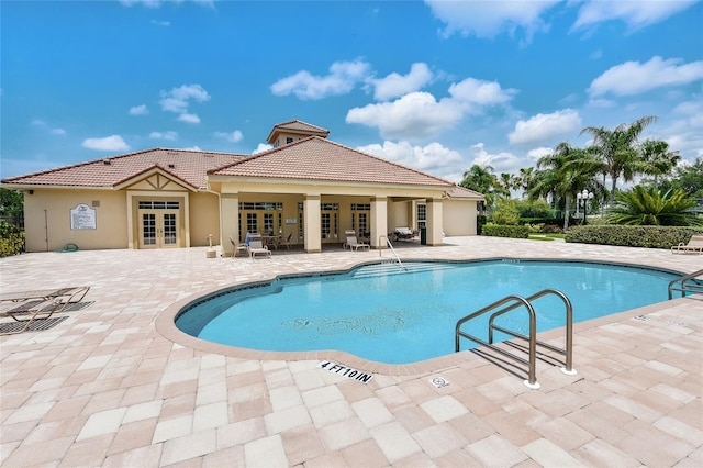 view of swimming pool with a patio and french doors