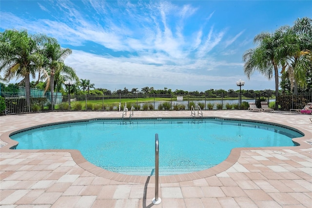 view of swimming pool featuring a patio and a water view