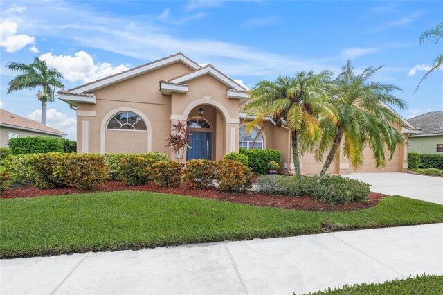 mediterranean / spanish-style home with a front yard and a garage