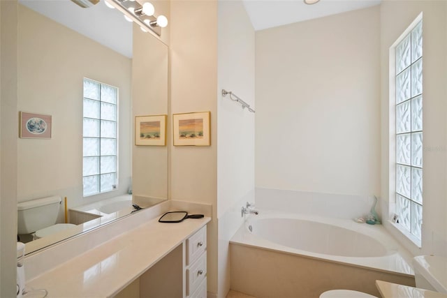 bathroom with a bathing tub, vanity, and toilet